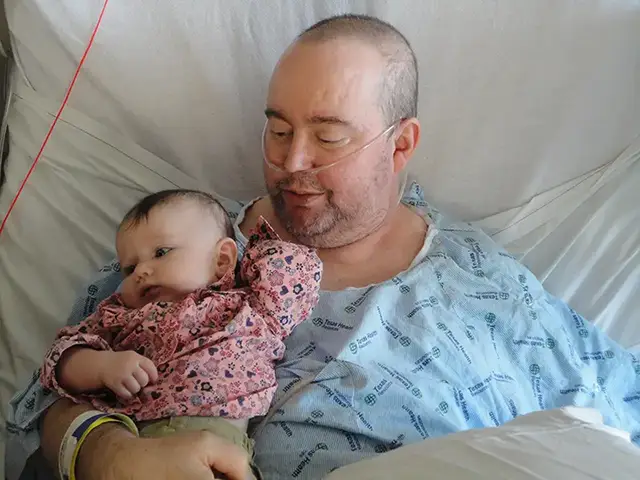 Bruce holding Phoebe a few weeks after she was born.